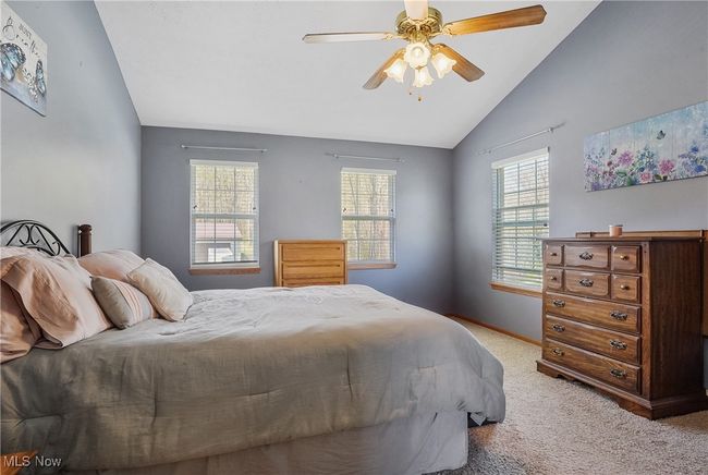 Bedroom featuring carpet, ceiling fan, vaulted ceiling, and baseboards | Image 28