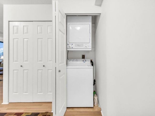 Laundry room with laundry area, light wood finished floors, and stacked washer / dryer | Image 13
