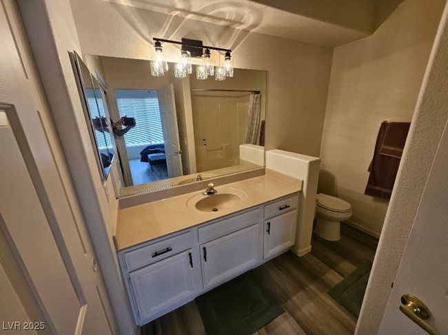 Bathroom featuring a shower with curtain, wood finished floors, vanity, and toilet | Image 21