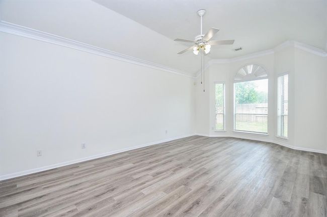 Your 14' x 22' primary bedroom has details of crown molding and bay windows that fill the space with natural light during the day. Located on the first floor, it offers added convenience and a quiet retreat from the rest of the home. | Image 16