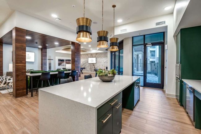 Kitchen featuring decorative light fixtures, light hardwood / wood-style floors, decorative columns, and a spacious island | Image 33