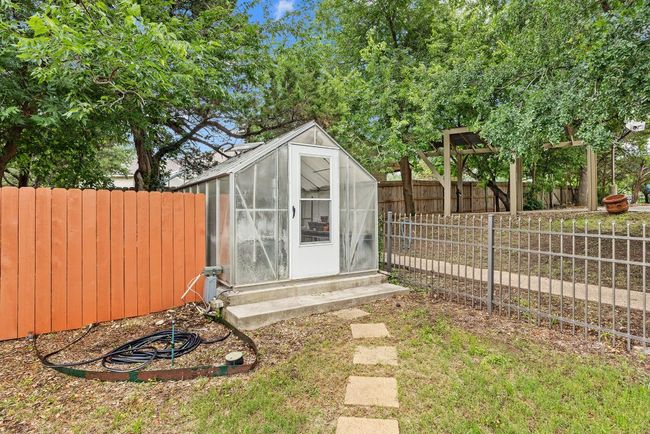 View of greenhouse with a fenced backyard | Image 34