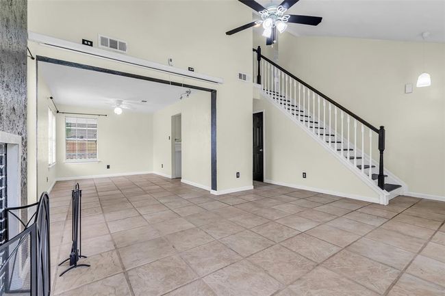 From this corner of the living room, you can see the staircase to the second floor and the dining area, which flows seamlessly into the space. | Image 7