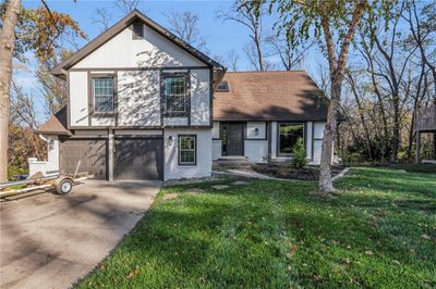 View of front facade featuring a front lawn and a garage | Image 1