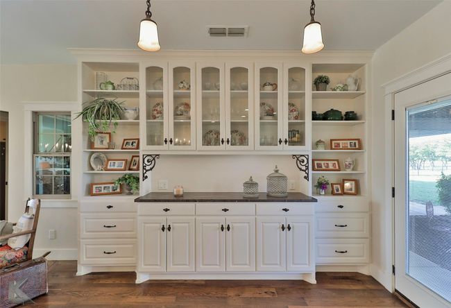 Bar area featuring hanging light fixtures and dark wood-style floors | Image 11