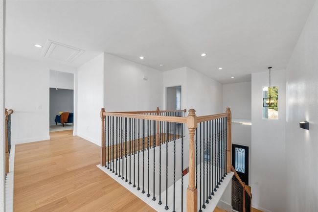 Stunning wood floors complement the gorgeous wood railings, overlooking the spacious family living area. A well-designed layout provides ample walking space leading to the bedrooms, media room, and recreational room, enhancing both style and functionality. | Image 23