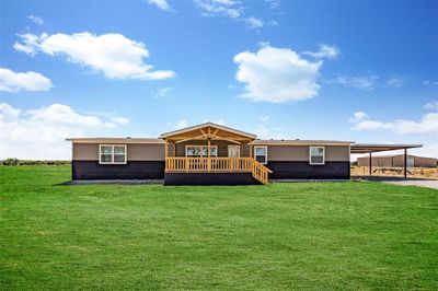 Back of house featuring a yard and a carport | Image 1