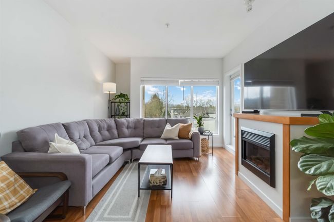Living area featuring a glass covered fireplace and light wood-style flooring | Image 6