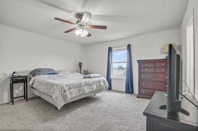 Large primary bedroom with ceiling fan and brand new carpet | Image 14
