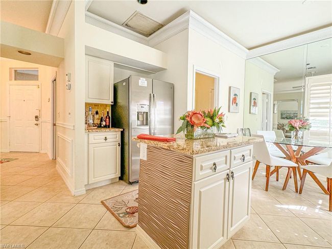 Kitchen with light stone counters, stainless steel fridge with ice dispenser, light tile floors, and tasteful backsplash | Image 36