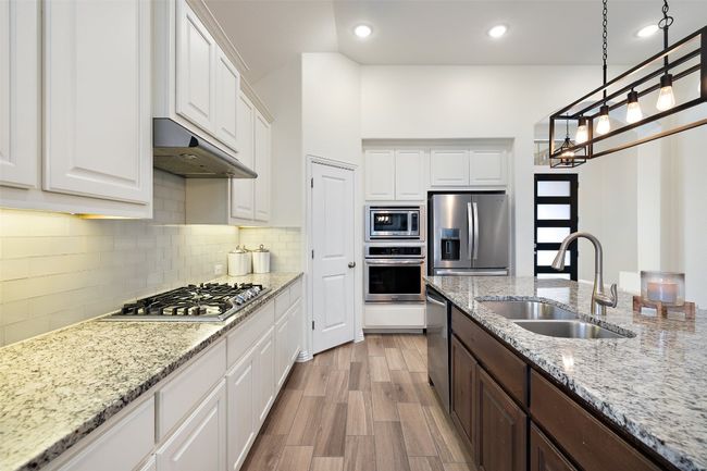 The kitchen and main living spaces feature wood-look tile for a cohesive, low-maintenance, and elegant finish. | Image 11