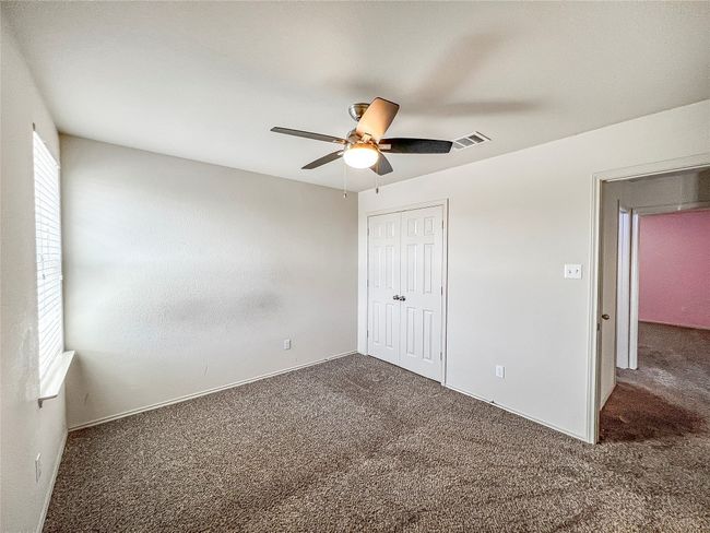 Unfurnished bedroom with carpet flooring, a closet, and ceiling fan | Image 22