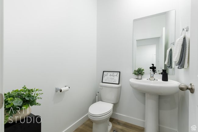 Bathroom featuring baseboards, wood finished floors, and toilet | Image 8