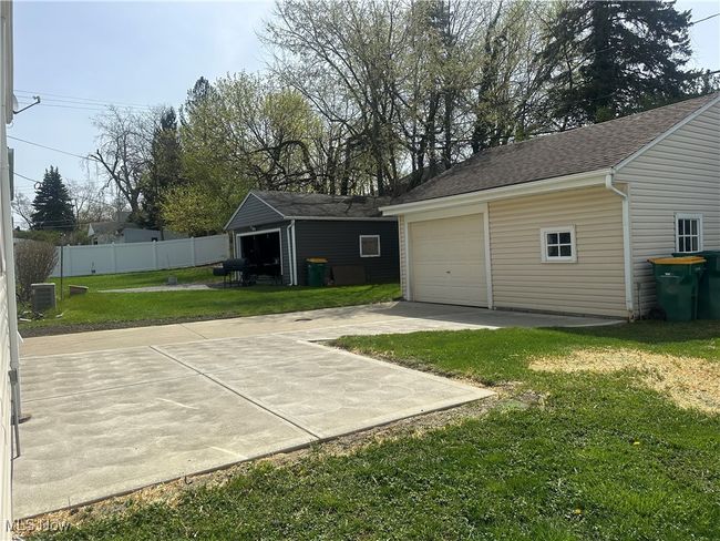 Garage with fence, cooling unit, and driveway | Image 10