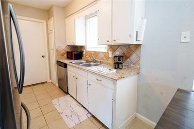 Kitchen with white cabinetry, appliances with stainless steel finishes, tasteful backsplash, and sink | Image 3