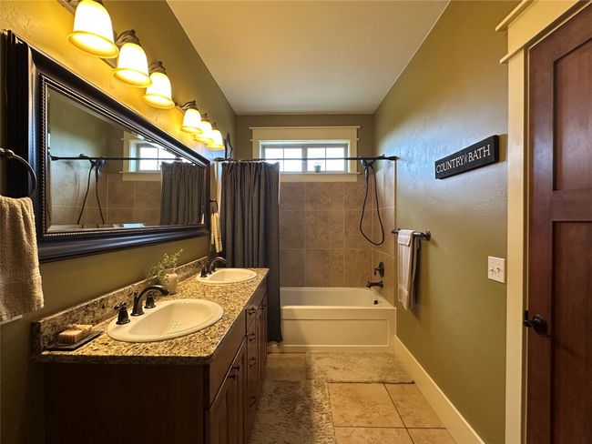 Full bath featuring shower / bath combo, double vanity, and tile patterned flooring | Image 14