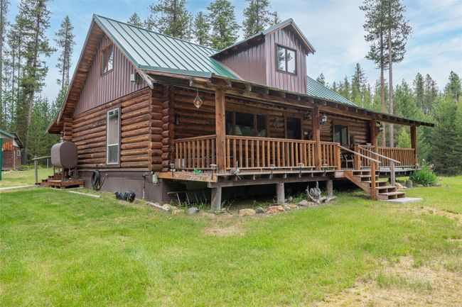 View of front of home featuring log siding, a front lawn, a metal roof, and a standing seam roof | Image 21