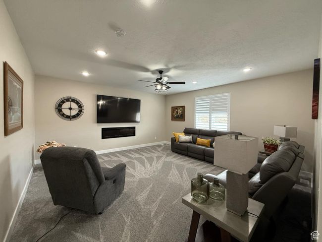 Carpeted living area with baseboards, a textured ceiling, recessed lighting, and a ceiling fan | Image 53