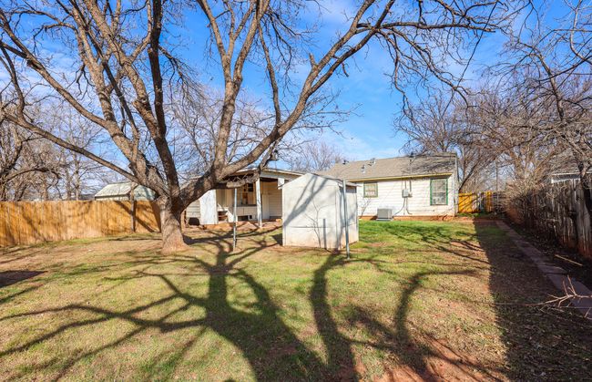 View of yard featuring an outbuilding, a fenced backyard, cooling unit, and a storage shed | Image 29