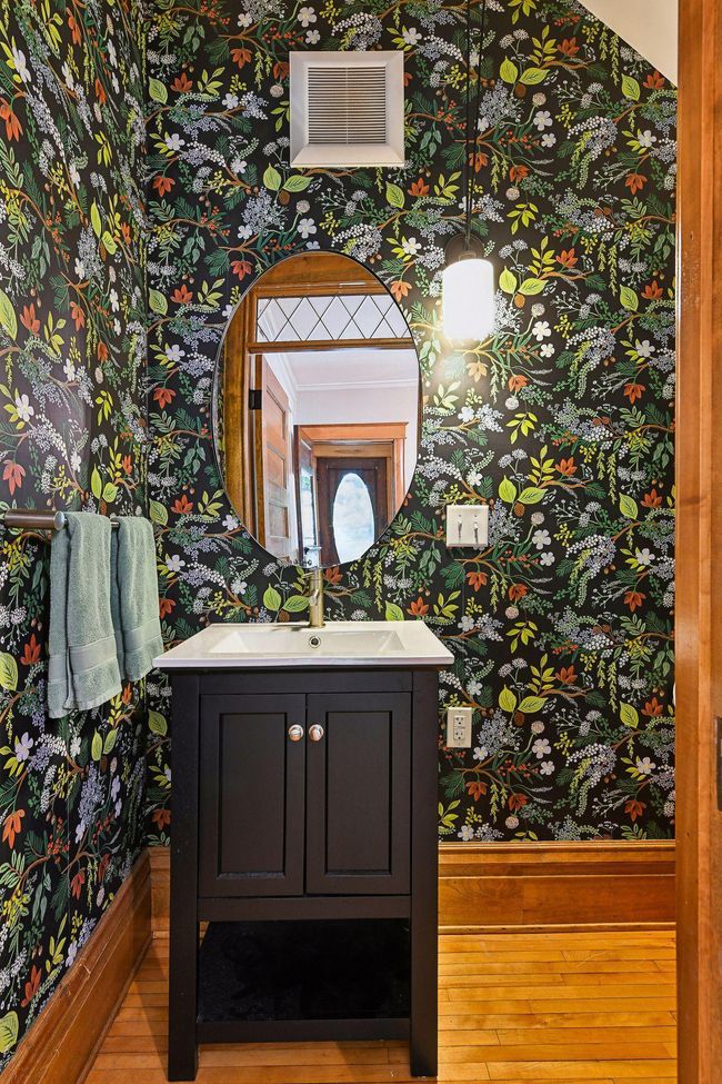 Adorable bathroom remodeled with fresh wallpaper, vanity & toilet. | Image 13