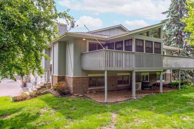 Enjoy morning coffee or evening gatherings on the spacious elevated deck with access to the enclosed 3-season porch overlooking the backyard. | Image 33