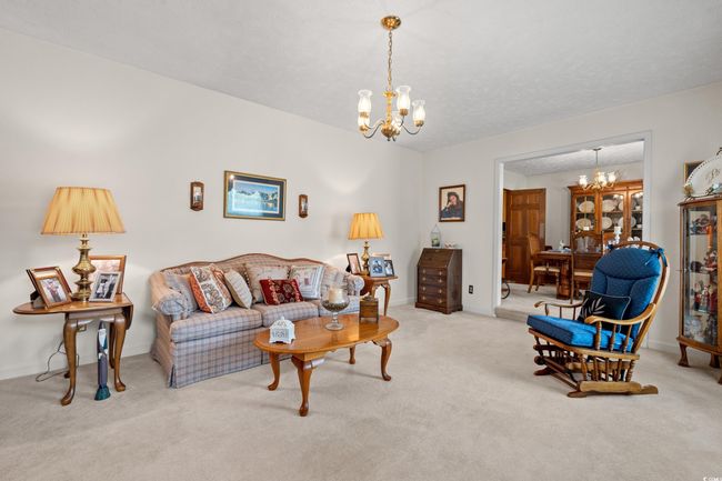 Living room featuring baseboards, carpet flooring, and a notable chandelier | Image 9