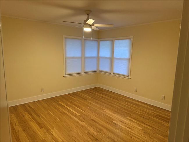 Unfurnished room featuring ceiling fan, light wood-style flooring, and ornamental molding | Image 23