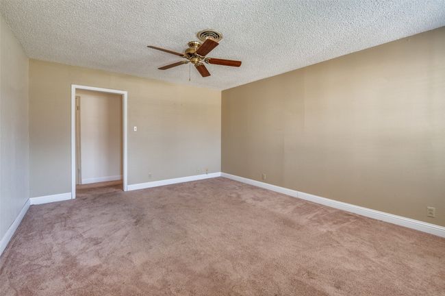 Unfurnished room with ceiling fan, carpet flooring, and a textured ceiling | Image 6