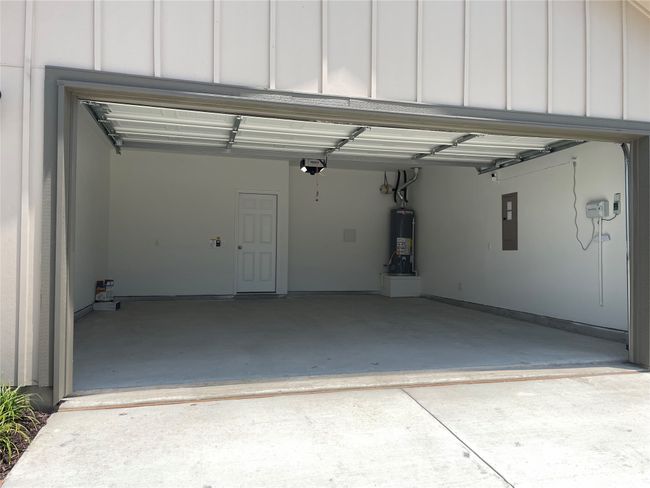 Garage with water heater, electric panel, and a garage door opener | Image 22