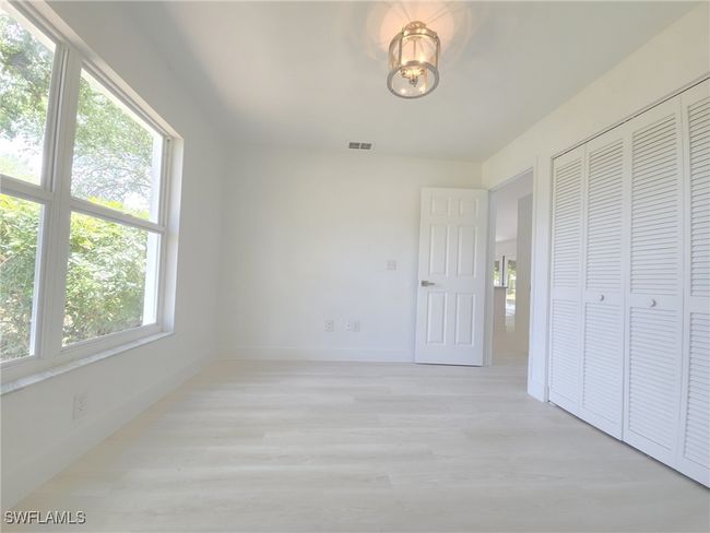 Unfurnished bedroom with light wood-type flooring, a closet, baseboards, and a chandelier | Image 36
