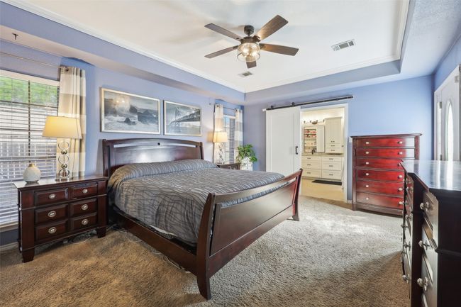 Primary bedroom with added barn door for privacy offers plenty of space for furniture and convenient access to the backyard. | Image 19