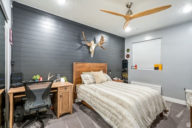 Bedroom featuring light carpet, a desk, and a ceiling fan | Image 77