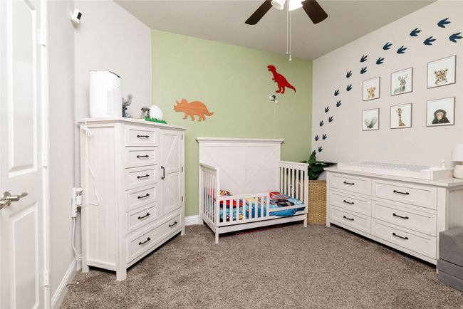 Bedroom featuring light colored carpet, baseboards and ceiling fan | Image 11