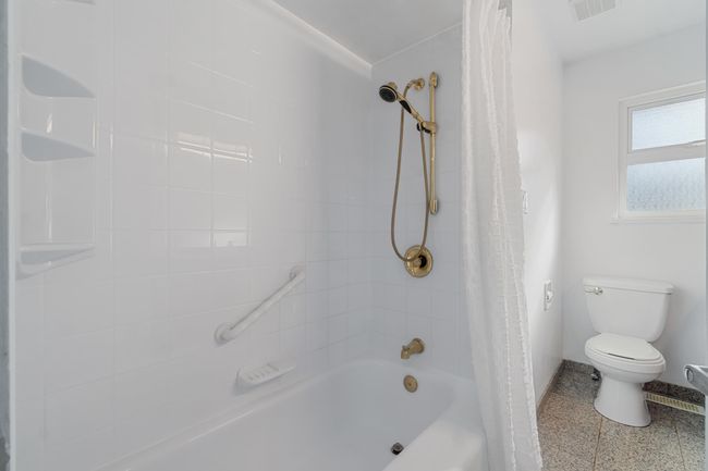 Bathroom featuring toilet, shower / bath combination with curtain, and visible vents | Image 11