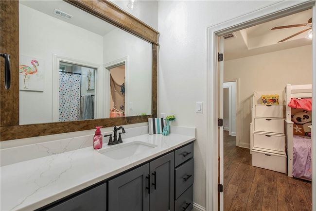 Bathroom featuring visible vents, ceiling fan, vanity, and wood finished floors | Image 20