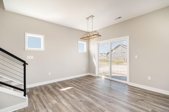 Off the sunny dining space are patio doors that face the west and another upgrade for long lasting durability is the Cable Handrail System going to the upper level. | Image 8