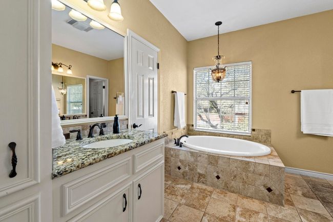Full bath featuring visible vents, a garden tub, a chandelier, and vanity | Image 22
