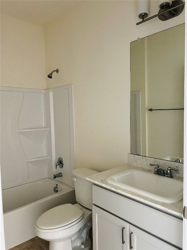 Second Full bathroom featuring vanity with trendy terrazzo countertops and a tub-shower combination. | Image 16