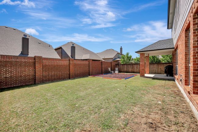 Outside, enjoy shade under the covered patio or roam in this yard | Image 39