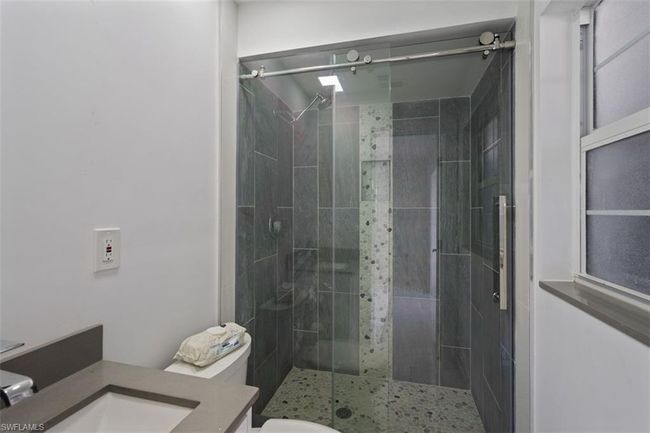 Full bathroom featuring vanity, a shower stall, and toilet | Image 16