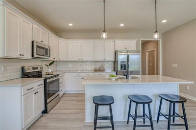 Kitchen with light wood-type flooring, appliances with stainless steel finishes, and backsplash | Image 2