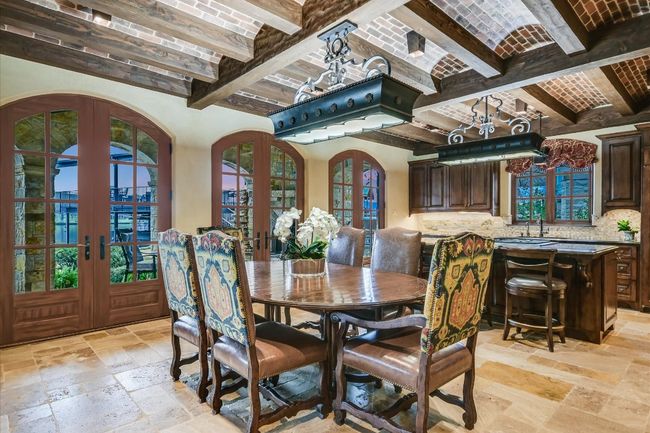 Dining space with beam ceiling, french doors, brick ceiling, and stone tile floors | Image 11