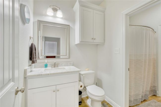 Full bathroom with vanity, wood finished floors, and a shower with shower curtain | Image 29