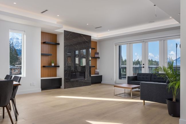 Living area featuring visible vents, a raised ceiling, recessed lighting, light wood finished floors, and baseboards | Image 11