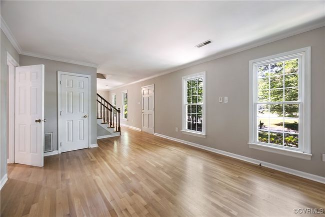 Living room with hardwood flooringstairway, and crown molding | Image 5