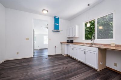 Kitchen featuring pendant lighting, sink, white cabinets, and dark wood-type flooring | Image 3