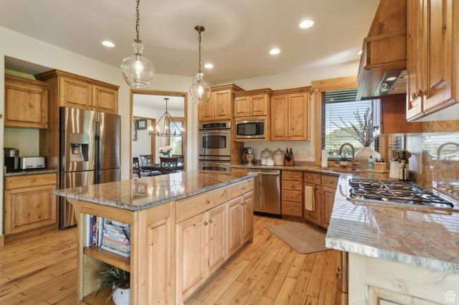 Kitchen featuring appliances with stainless steel finishes, a sink, light wood-style floors, light stone counters, and recessed lighting | Image 5