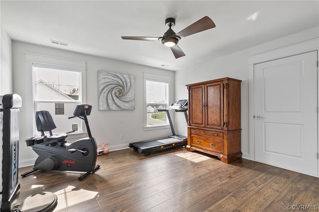 Exercise area featuring dark hardwood / wood-style flooring and ceiling fan | Image 34