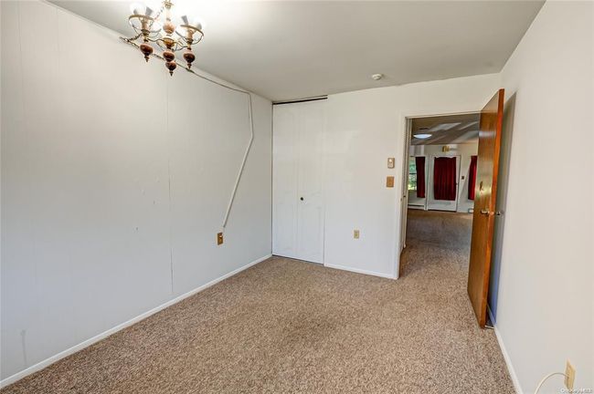 Empty room featuring light carpet and a chandelier | Image 8