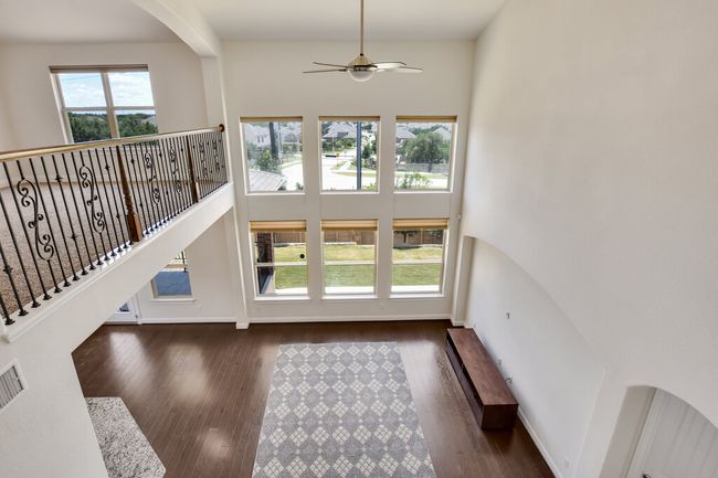 Entryway with a ceiling fan, wood finished floors, arched walkways, and a high ceiling | Image 35